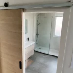 Porte coulissante salle de bain en applique bois dans salle d’eau moderne
